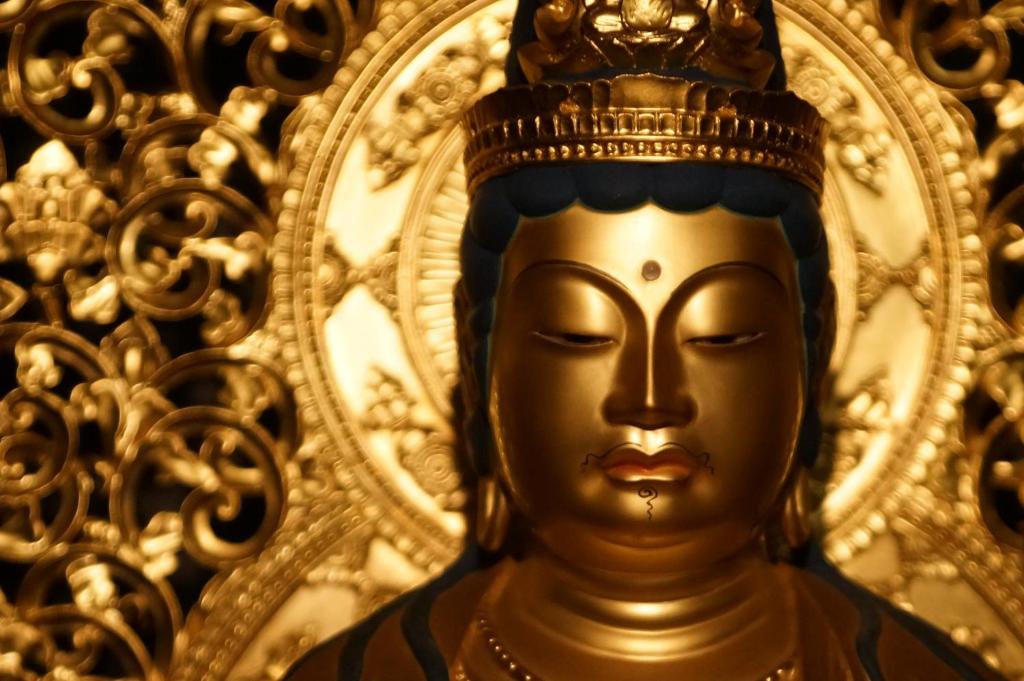 Una estatua dorada de Buda con una corona en la cabeza en 高野山 宿坊 西禅院 -Koyasan Shukubo Saizenin- en Koyasan