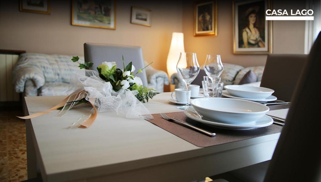 uma mesa com pratos, tigelas e flores em CasaLago di Erika e Antonella em Pisogne
