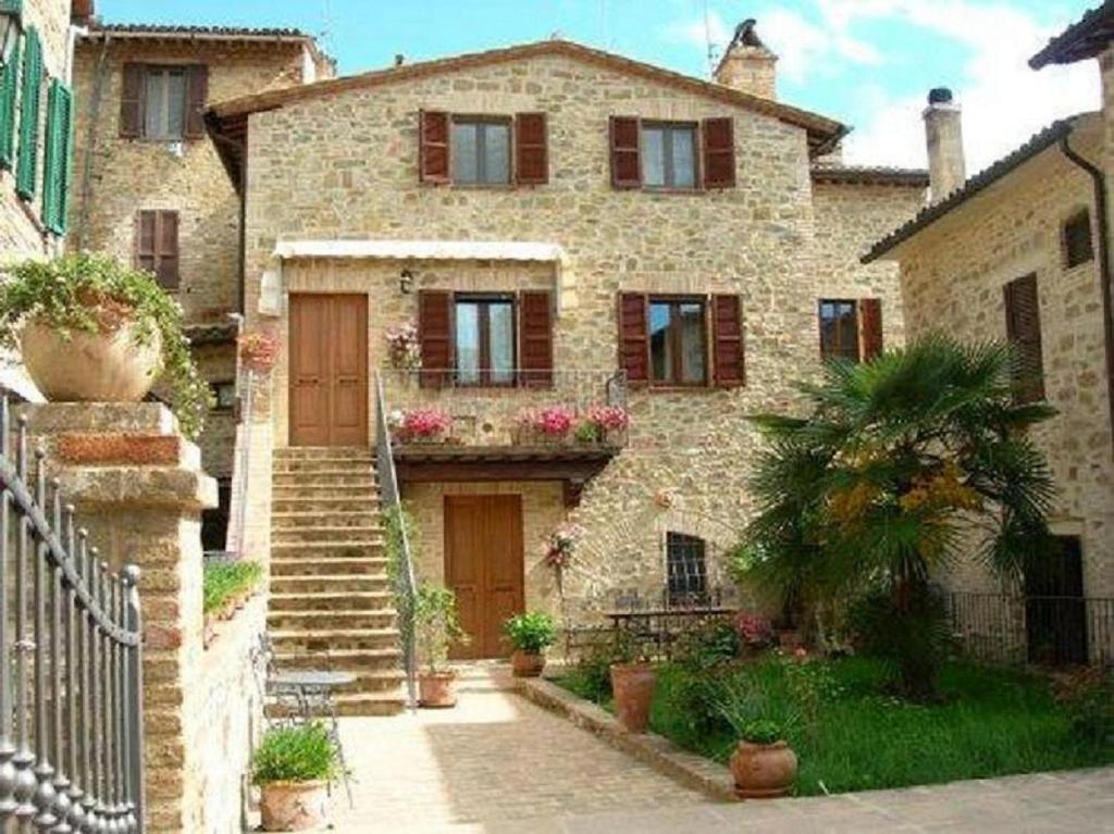 a stone house with a staircase in front of it at La Piazzetta in Bettona