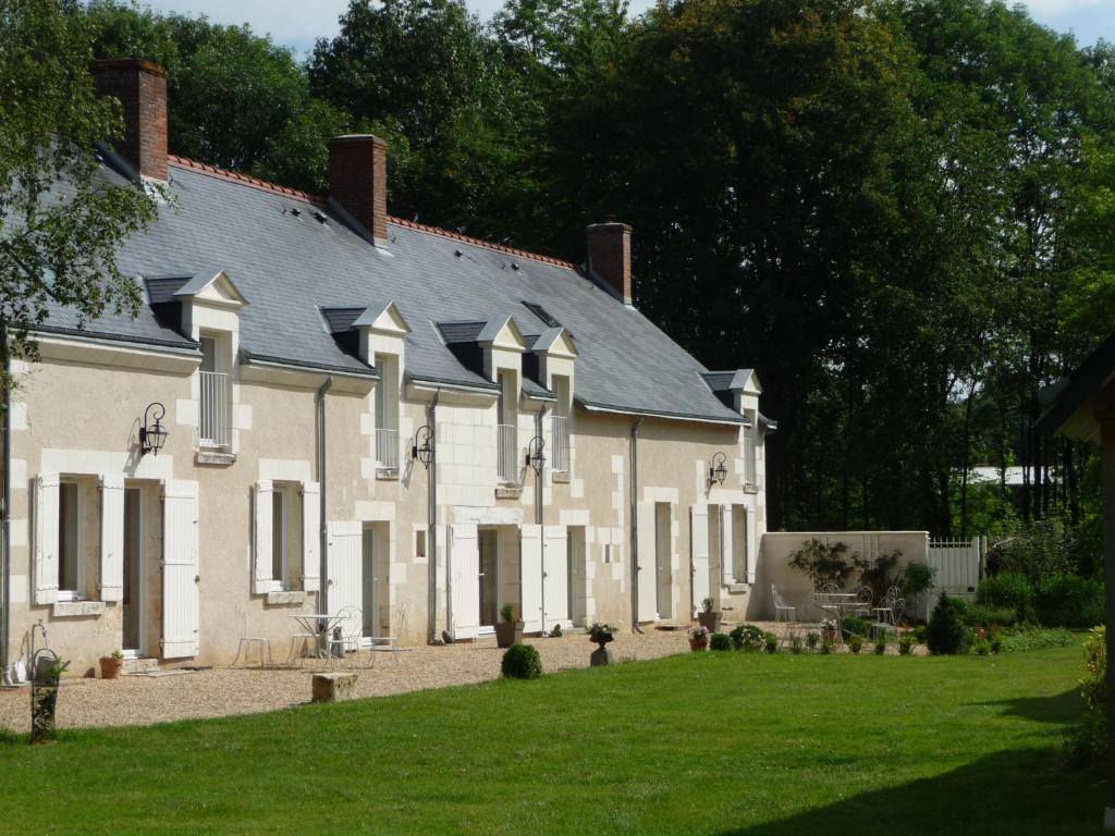 a large white building with a gray roof at La Blinerie in Sambin