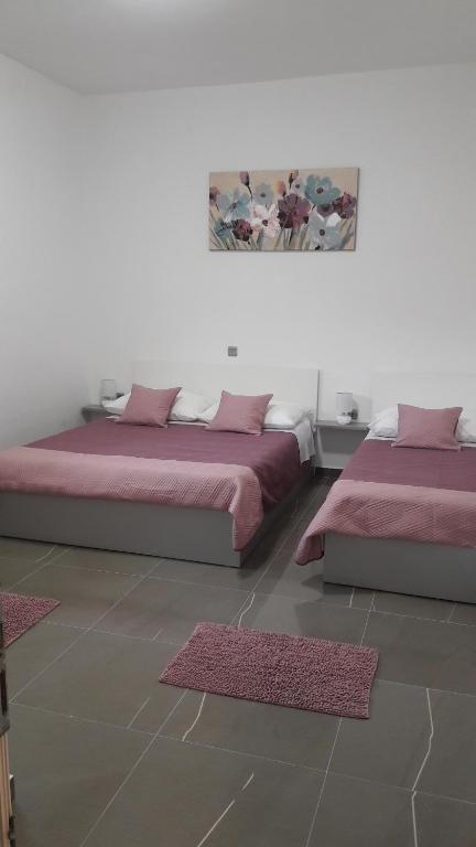 two beds sitting next to each other in a room at Apartmani Rudi in Vir