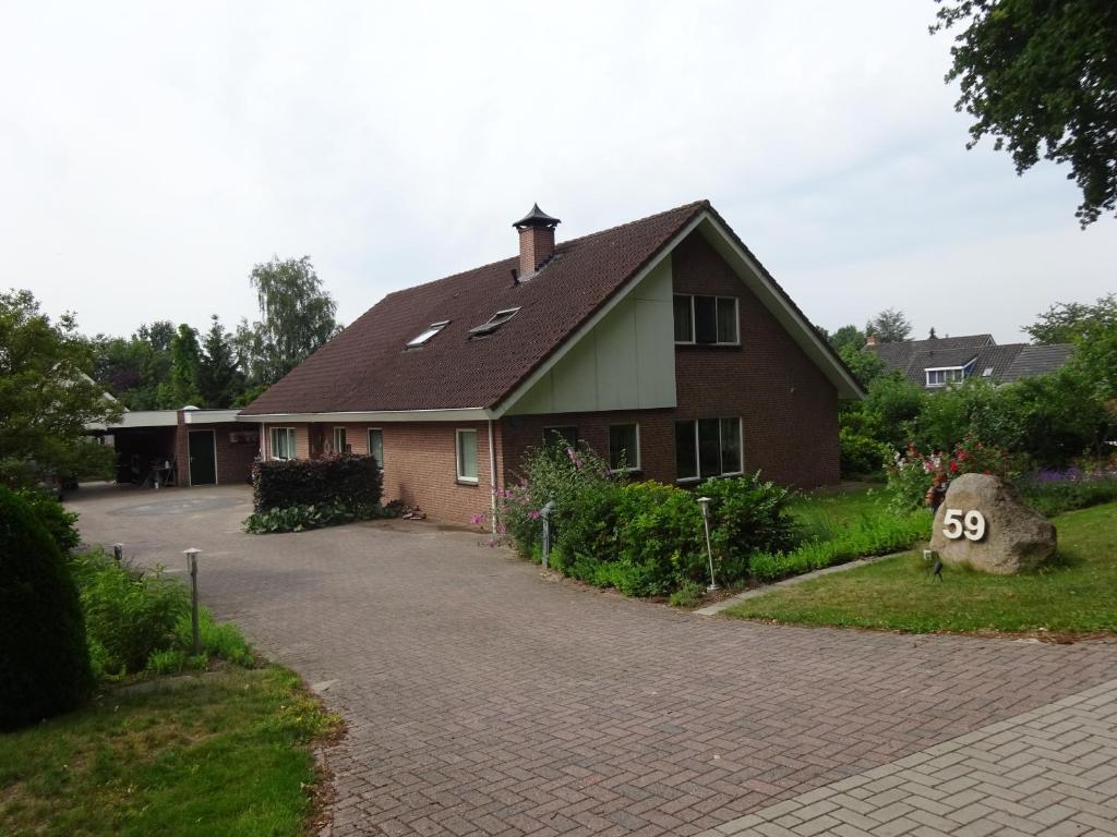 une maison avec un panneau dans l'allée dans l'établissement B&B Mendelts, à Emmen