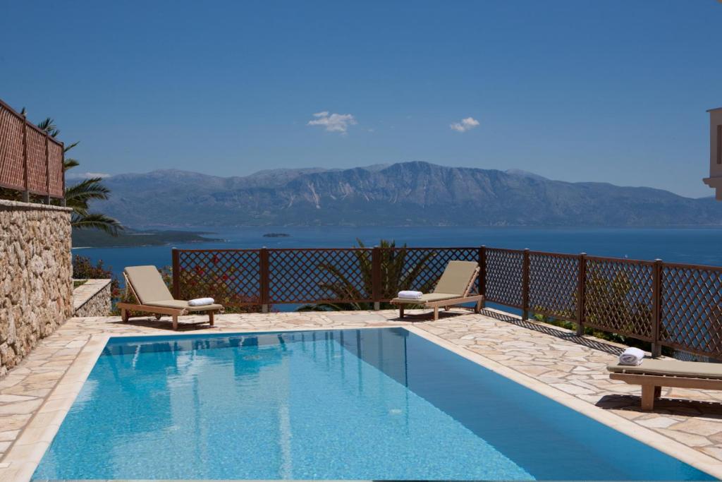 - une piscine avec deux chaises et une vue sur l'océan dans l'établissement Villa Aeropi, à Nikiana