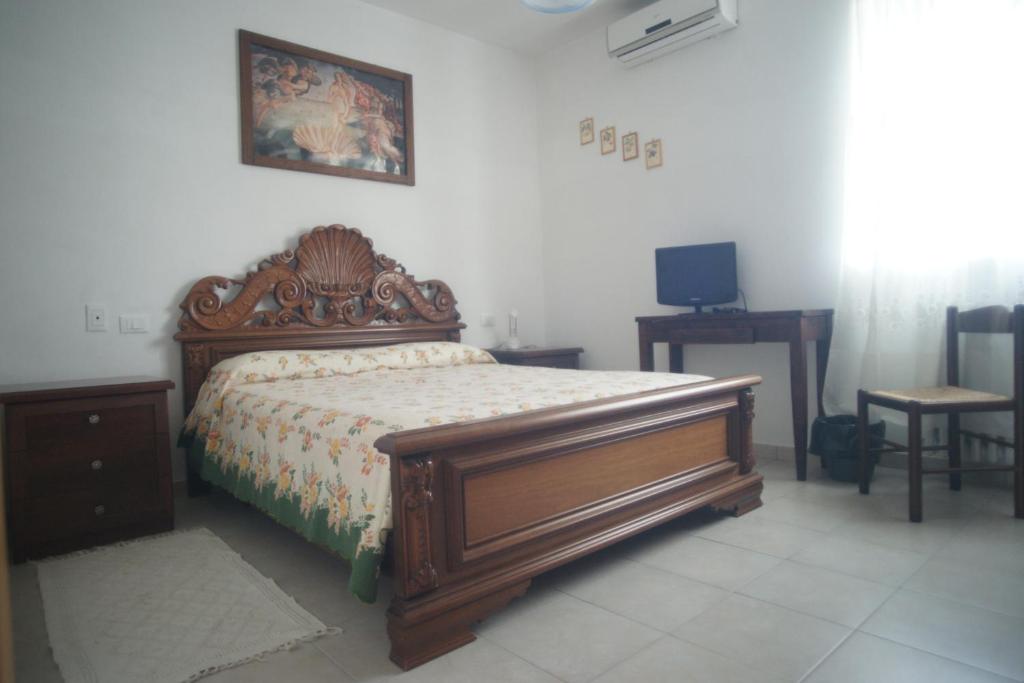 ein Schlafzimmer mit einem Holzbett in einem Zimmer in der Unterkunft Casale Giordano in Scerni