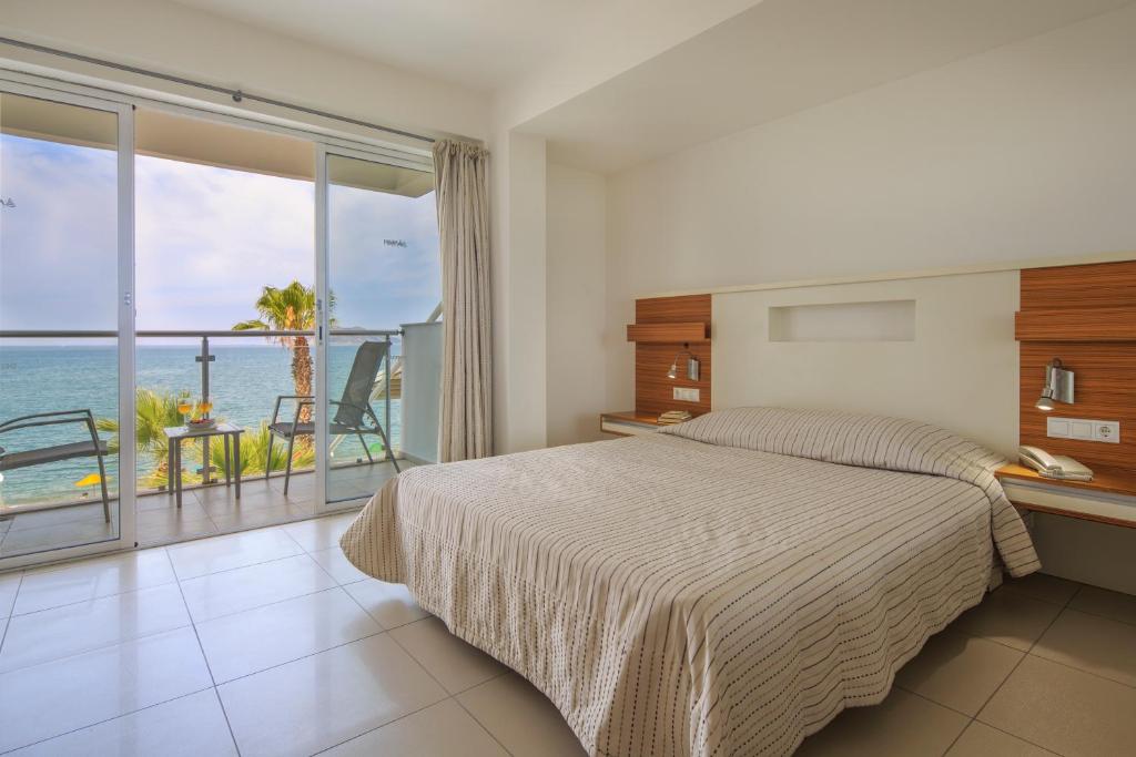 a bedroom with a bed and a view of the ocean at Hotel Delta in Fethiye