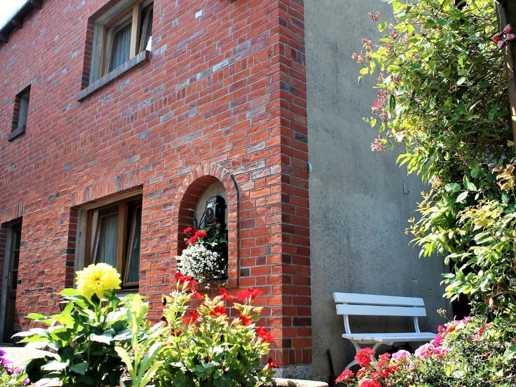 a brick building with a window and a bench at Klütz Garden Apartment in Klütz