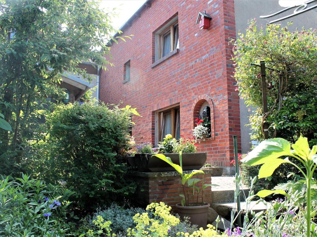 ceglany dom z ogrodem przed nim w obiekcie Cozy Apartment in Klutz Germany with a Lovely Garden w mieście Klütz