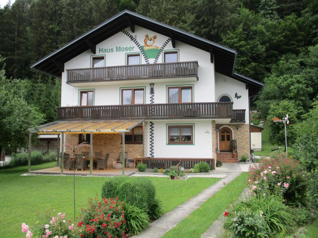 ein großes weißes Haus mit schwarzem Dach in der Unterkunft Haus Moser in Wörschach