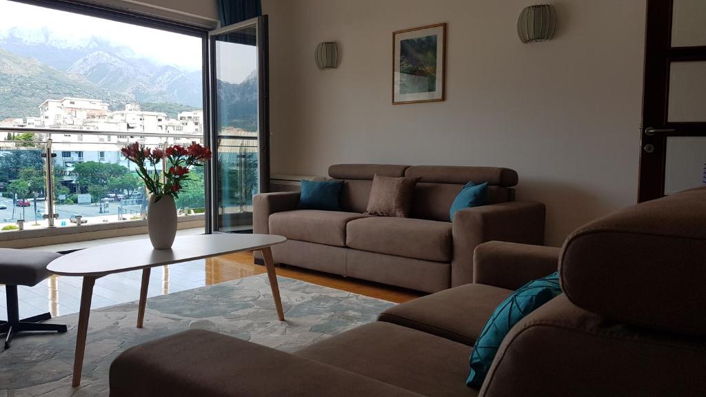 un soggiorno con un divano e un tavolo con fiori di Apartment Olive a Bar