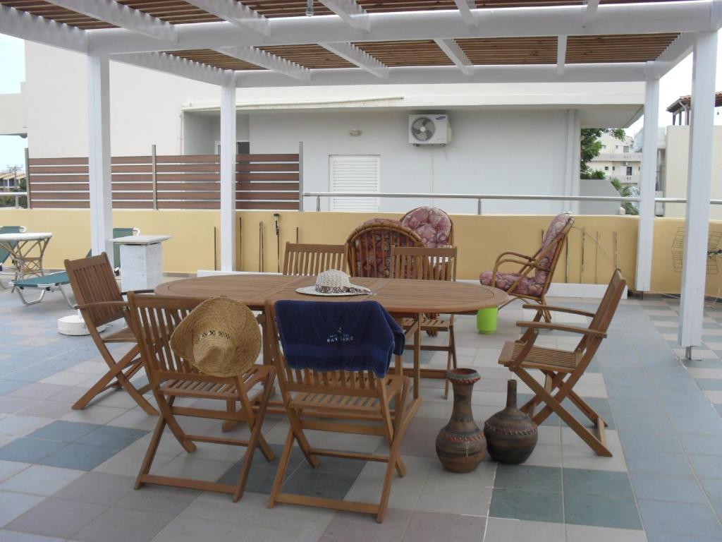 a wooden table and chairs on a patio at La Santre Villa in Amoudara Herakliou