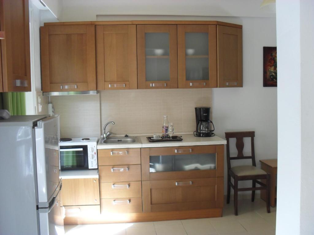 a kitchen with wooden cabinets and a refrigerator at La Santre Villa in Amoudara Herakliou