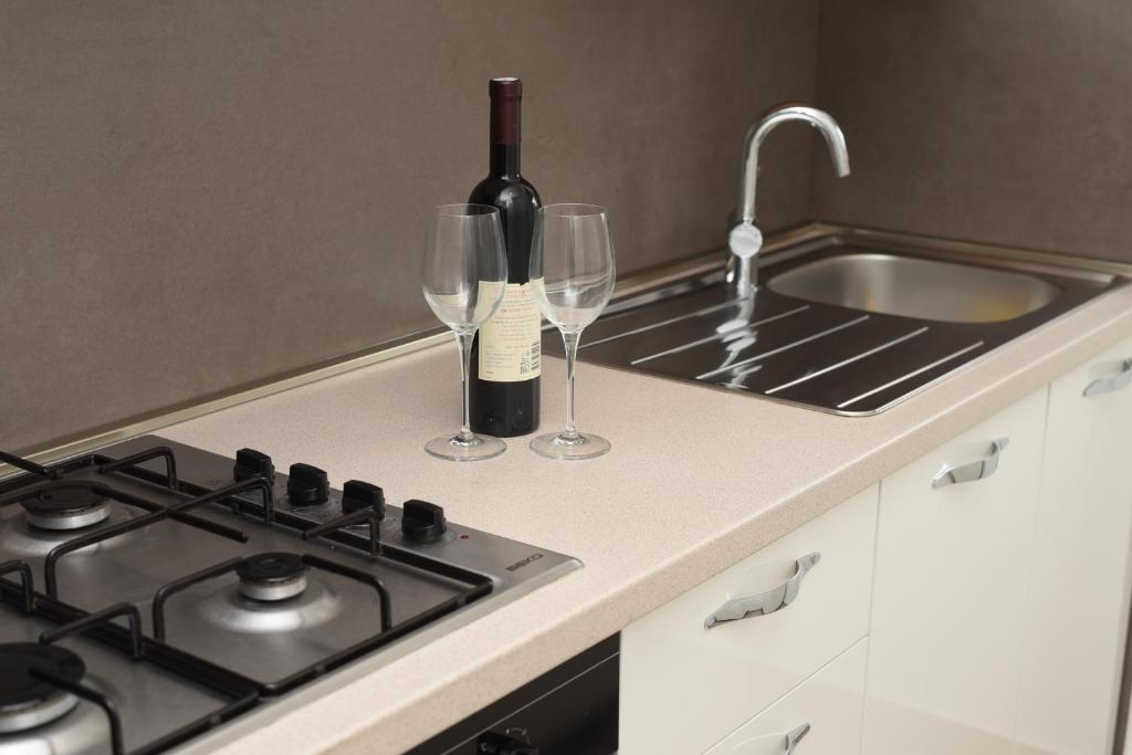 a kitchen with a stove and two wine glasses at Apartment Ćukušić in Split