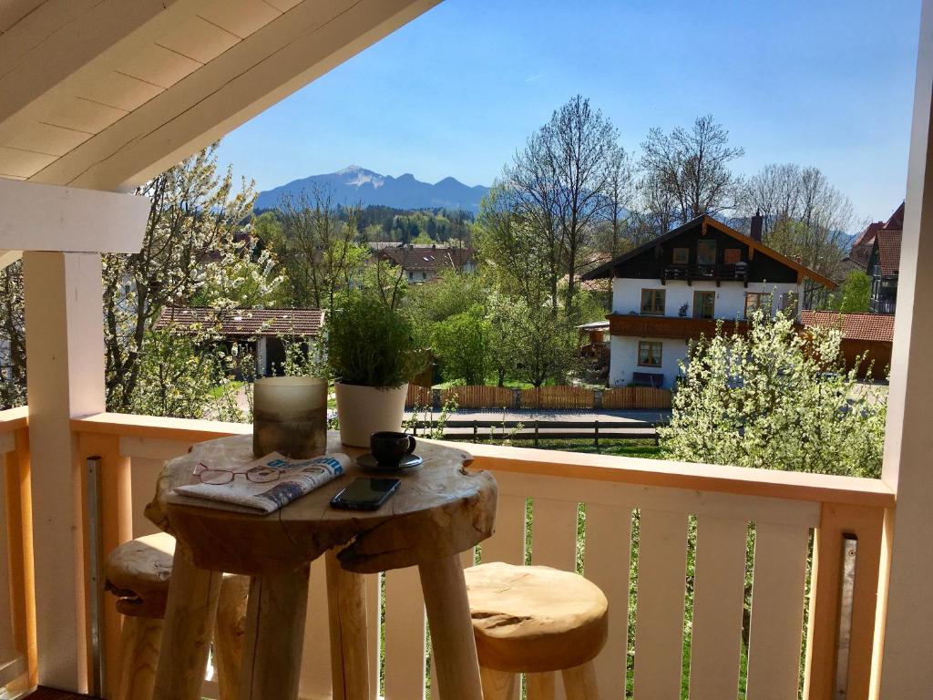a small table on a balcony with a view of the mountains at Shania Residence in Übersee
