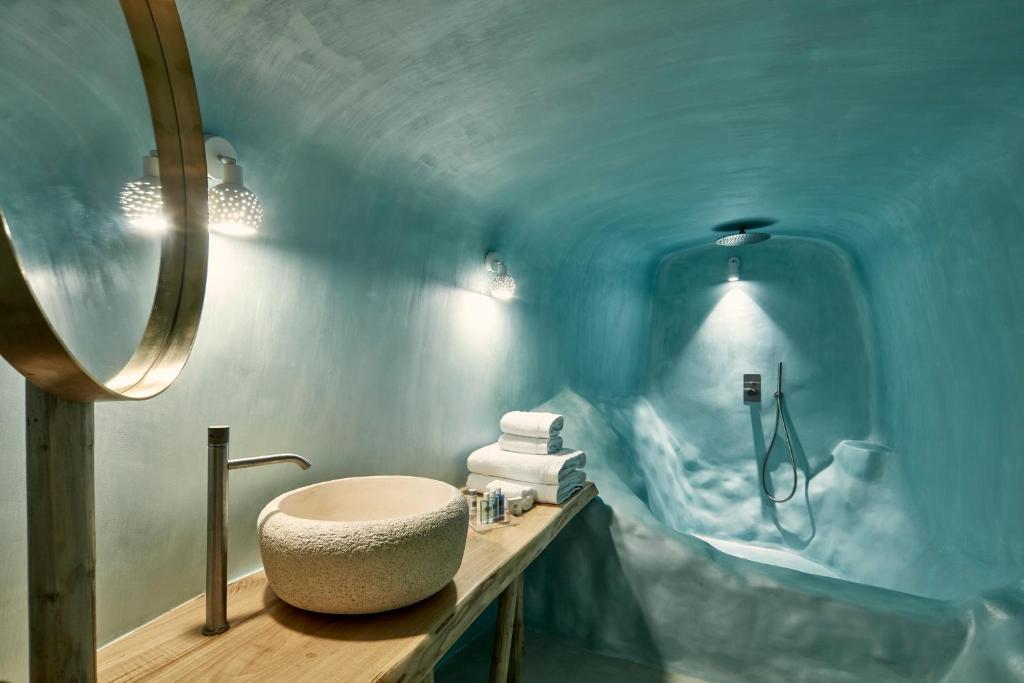 uma casa de banho com um lavatório num quarto azul em Limestone em Fira