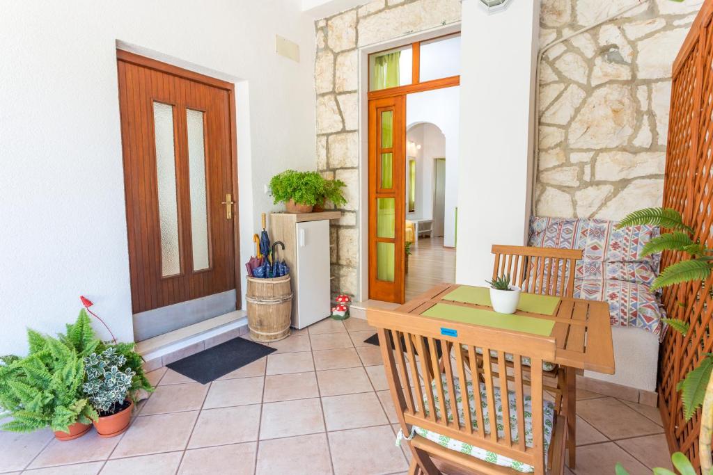 um alpendre com uma porta de madeira e uma mesa em Apartments Lukrecia em Hvar