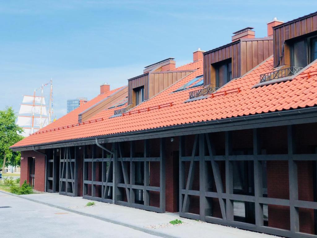 a red brick building with a red roof at Memel home old city apartment in Klaipėda