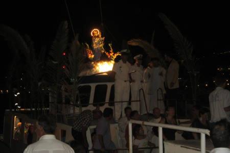 grupa ludzi stojących na łodzi w nocy w obiekcie Pietra di mare w mieście SantʼAgata di Militello