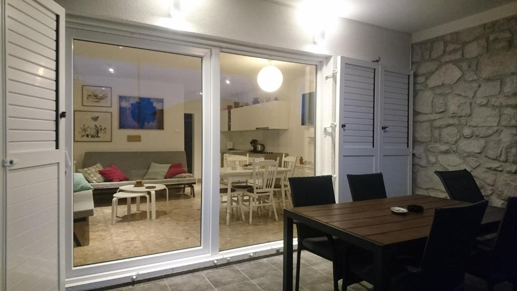 a dining room with a table and a living room at Sol Apartment in Baška