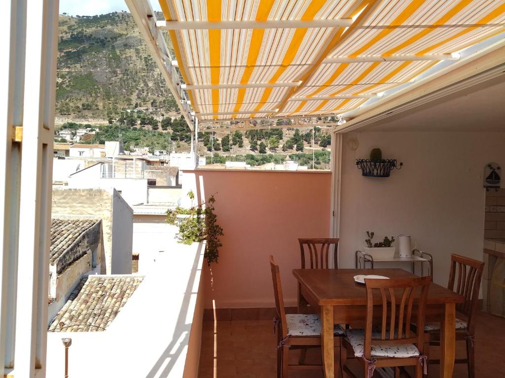 a dining room with a table and a balcony with a view at Heart of Castellammare in Castellammare del Golfo