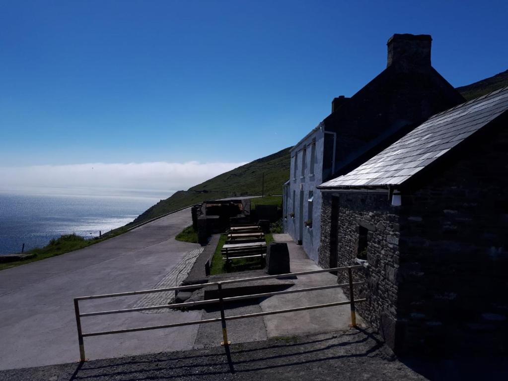 a building on the side of a hill with the ocean at Old Irish farmhouse in Dingle