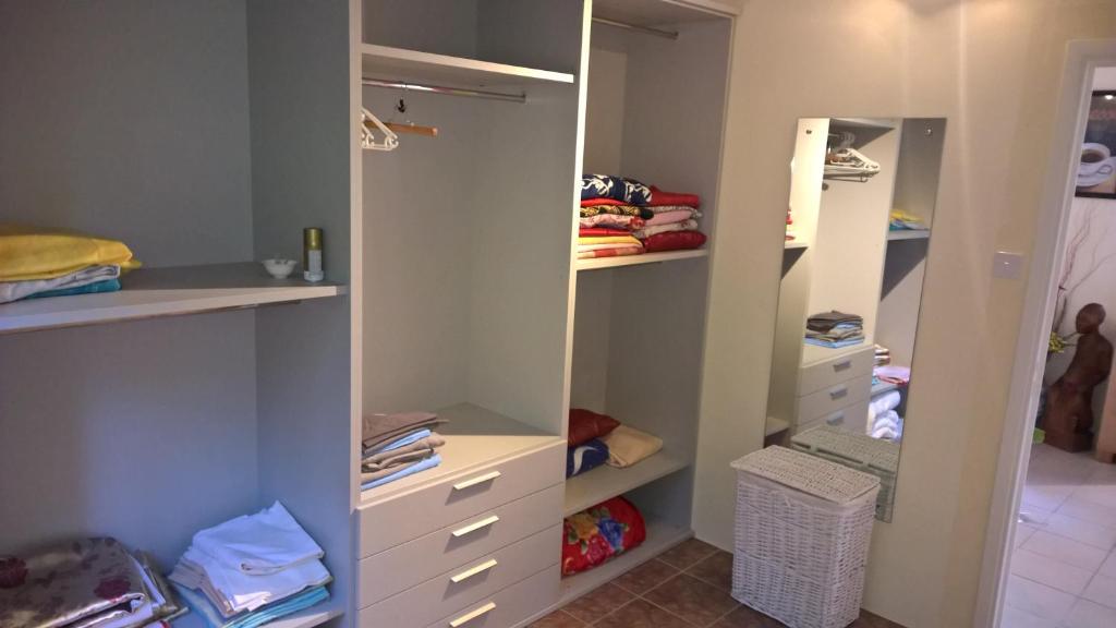 a walk in closet with white cabinets and drawers at VillaKapy idéal pour les retraitées in Pointe aux Cannoniers