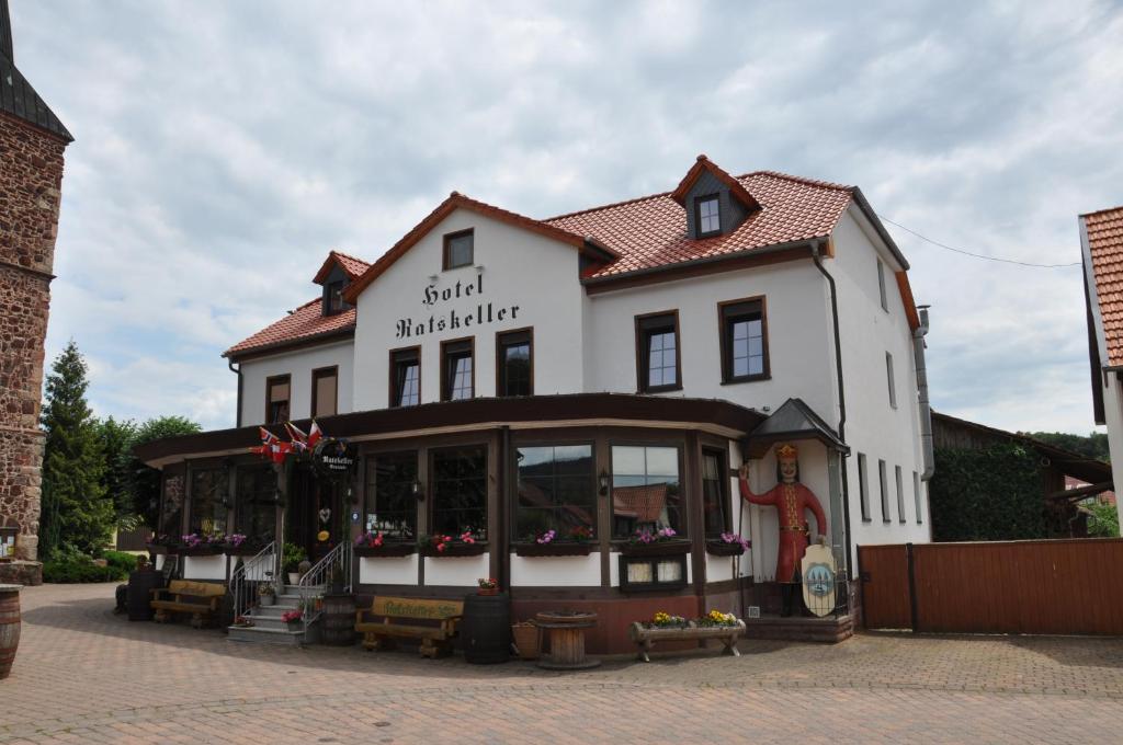 ein großes weißes Gebäude mit einem Laden davor in der Unterkunft Hotel Ratskeller in Neustadt