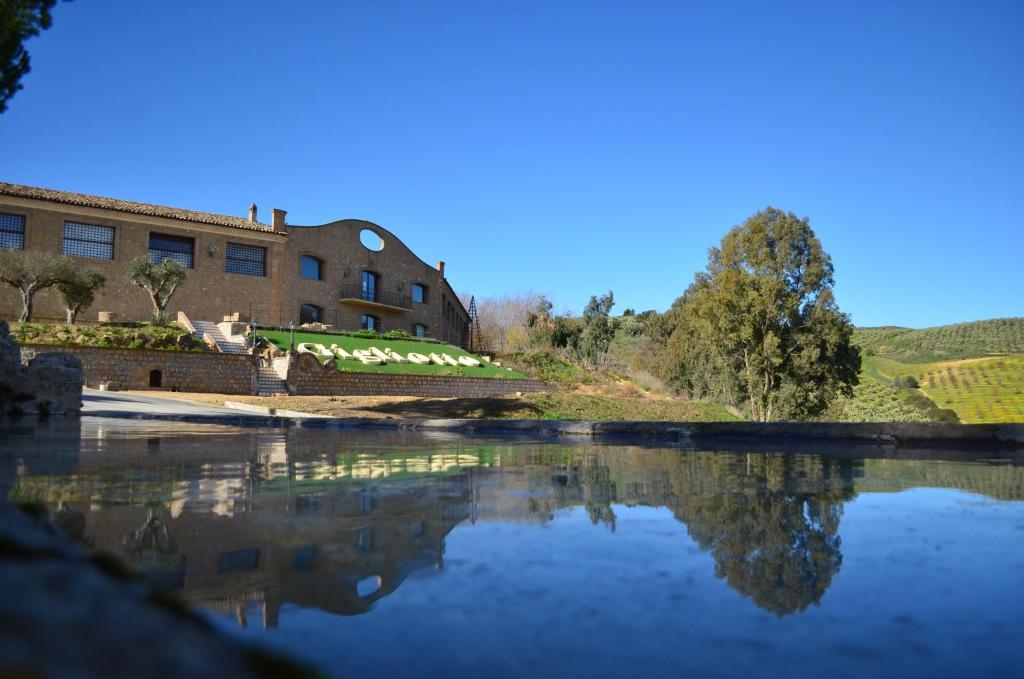 un reflet d'un bâtiment dans une masse d'eau dans l'établissement Tenute Gigliotto - B&B - Resort Wine - Agriturismo, à San Cono