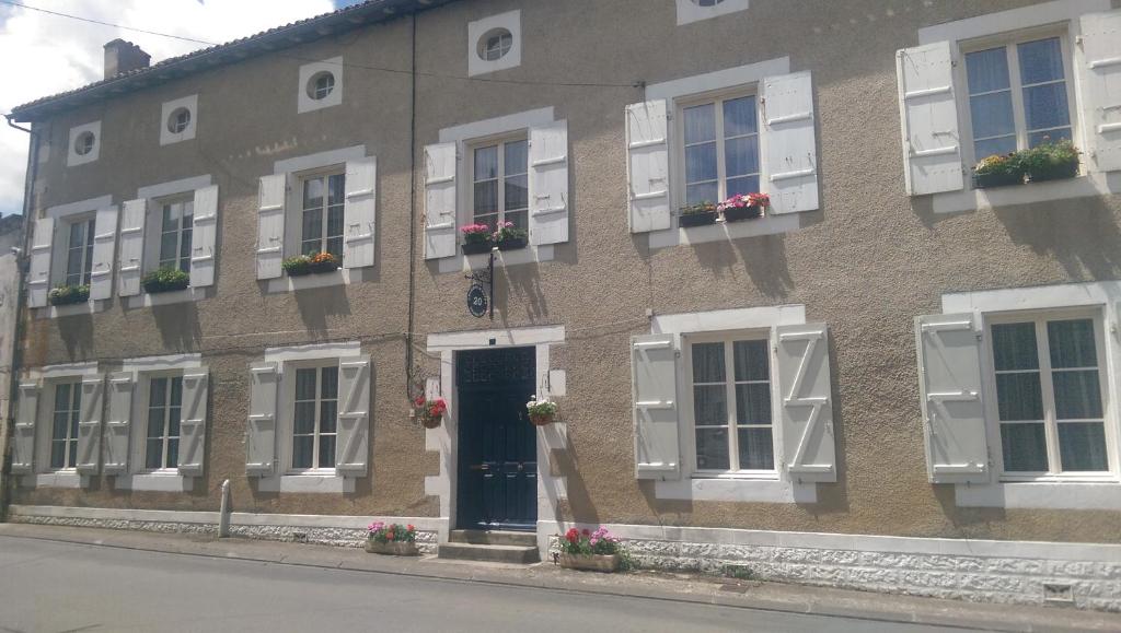 Champagne-MoutonにあるVingt Grand Rueの白い窓と青いドアが特徴のレンガ造りの建物