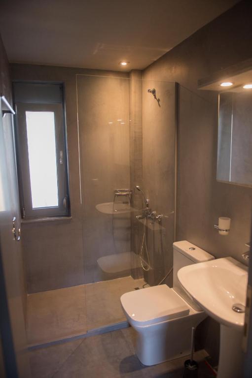 łazienka z prysznicem, toaletą i umywalką w obiekcie Agios Mamas Resort w mieście Nea Potidaea