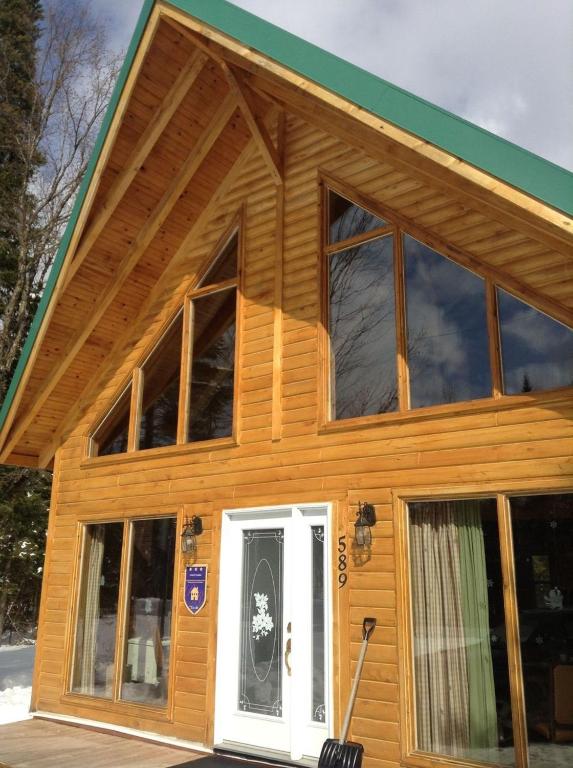 une maison avec de grandes fenêtres et une porte blanche dans l'établissement Chalet d'Anna, à Saint-Damien
