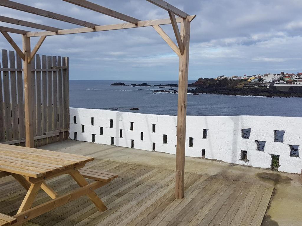 a wooden deck with a bench and a view of the ocean at Amazing view to the sea & port bay in Mosteiros in Mosteiros
