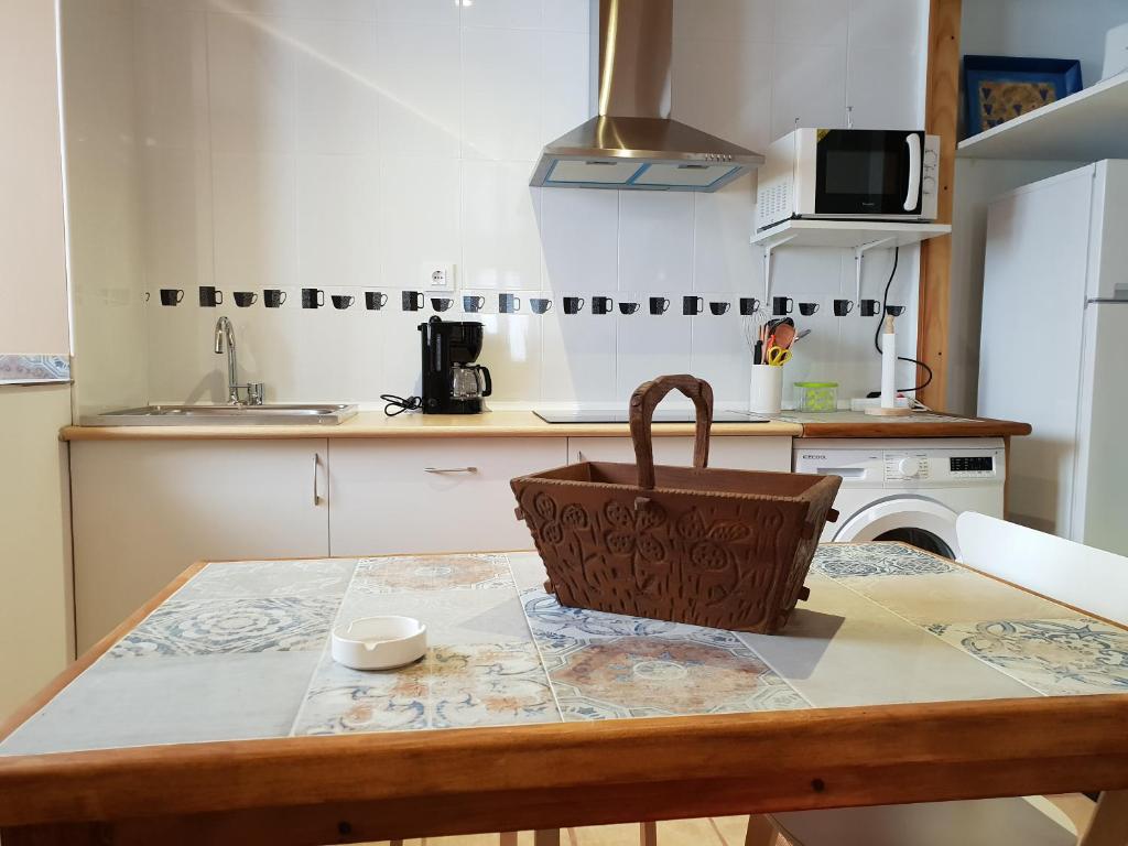 una cocina con una mesa con una cesta. en Casa Sara, en Colombres