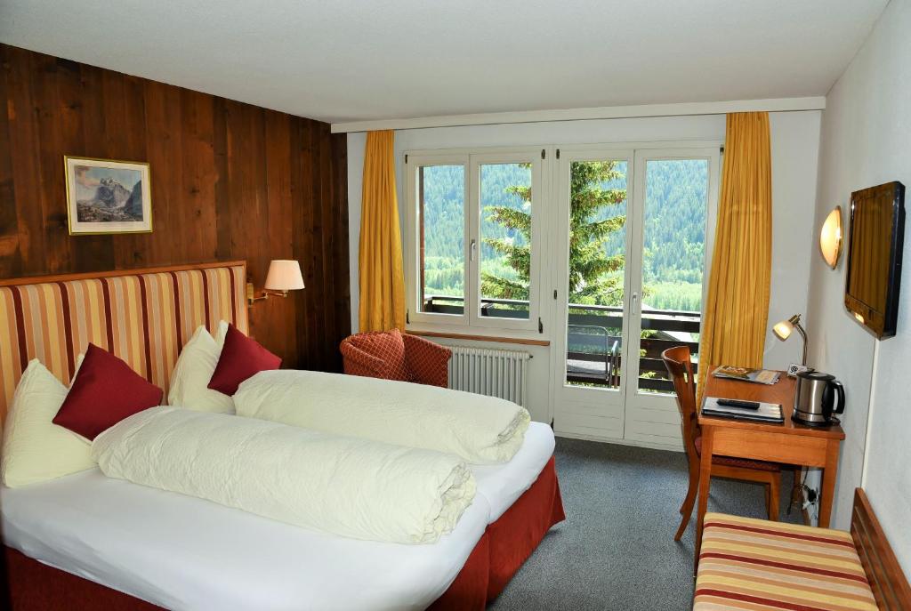 Ένα ή περισσότερα κρεβάτια σε δωμάτιο στο Hotel Tschuggen