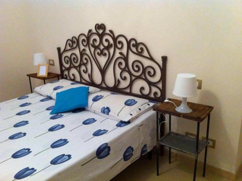 ein Schlafzimmer mit einem Bett mit einem Kopfteil aus Metall und einem Stuhl in der Unterkunft La ginestra gialla in Albinia