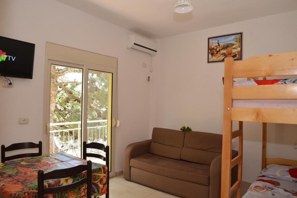1 dormitorio con litera y sofá en Hotel Gonaj, en Velipojë