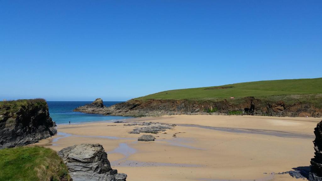 a sandy beach next to the ocean with cliffs at Sunways in Padstow