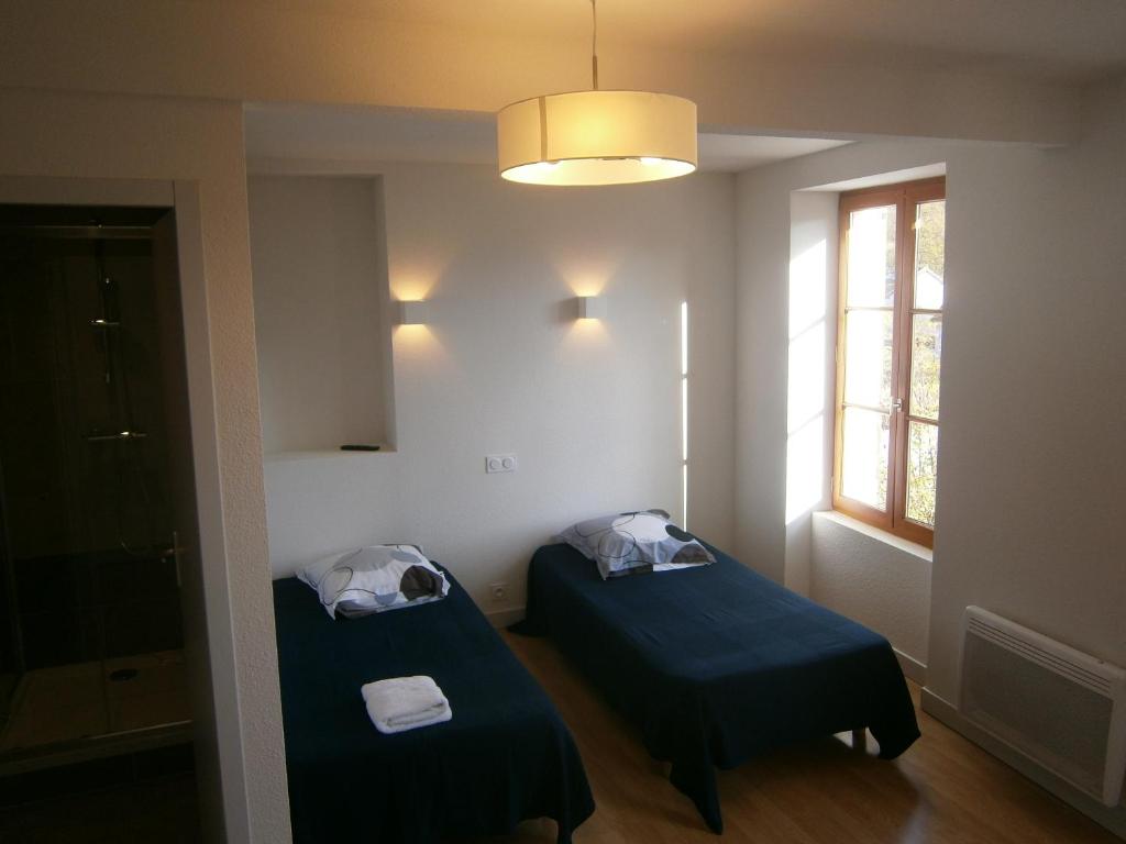 2 Betten in einem kleinen Zimmer mit Fenster in der Unterkunft Les Dimathal in Mens
