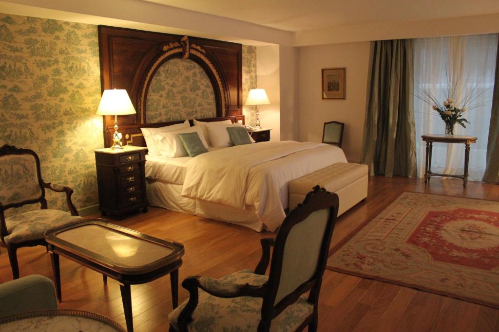 a bedroom with a large bed and a chair at Hotel Club Frances in Buenos Aires