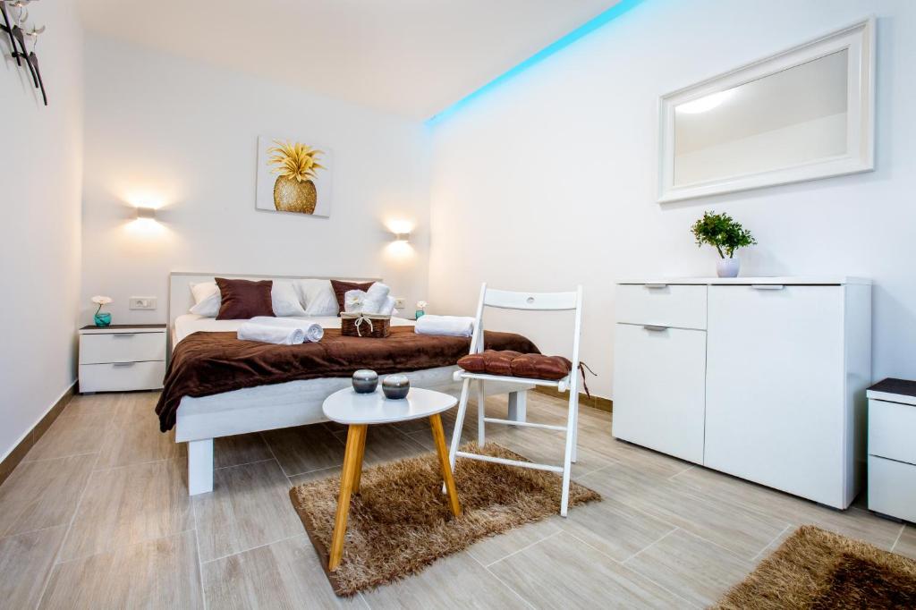een witte slaapkamer met een bed en een tafel bij Apartment Nives in the City Center - Free Parking in Split