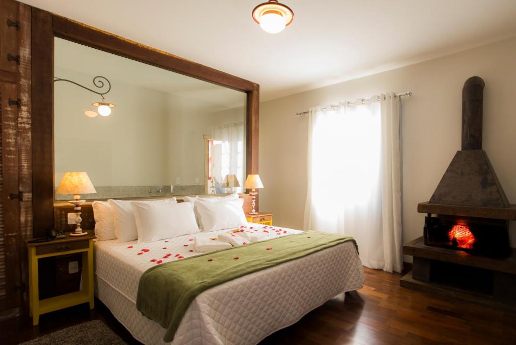 a bedroom with a bed with a large mirror at Pousada Ouro de Minas in Tiradentes