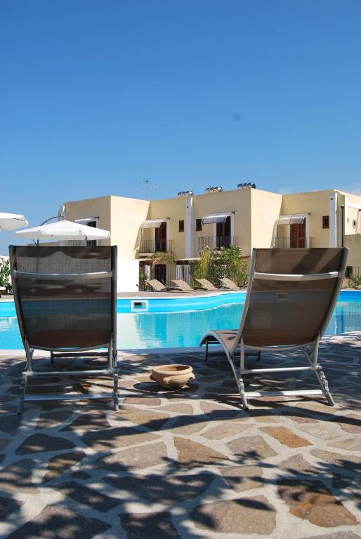 two chairs sitting next to a swimming pool at Villa Saraceno in Lipari