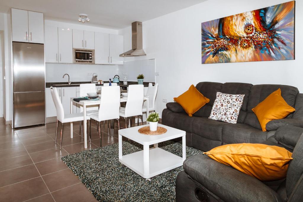 a living room with a couch and a table and a kitchen at Apartamento Victoria in Puerto del Carmen