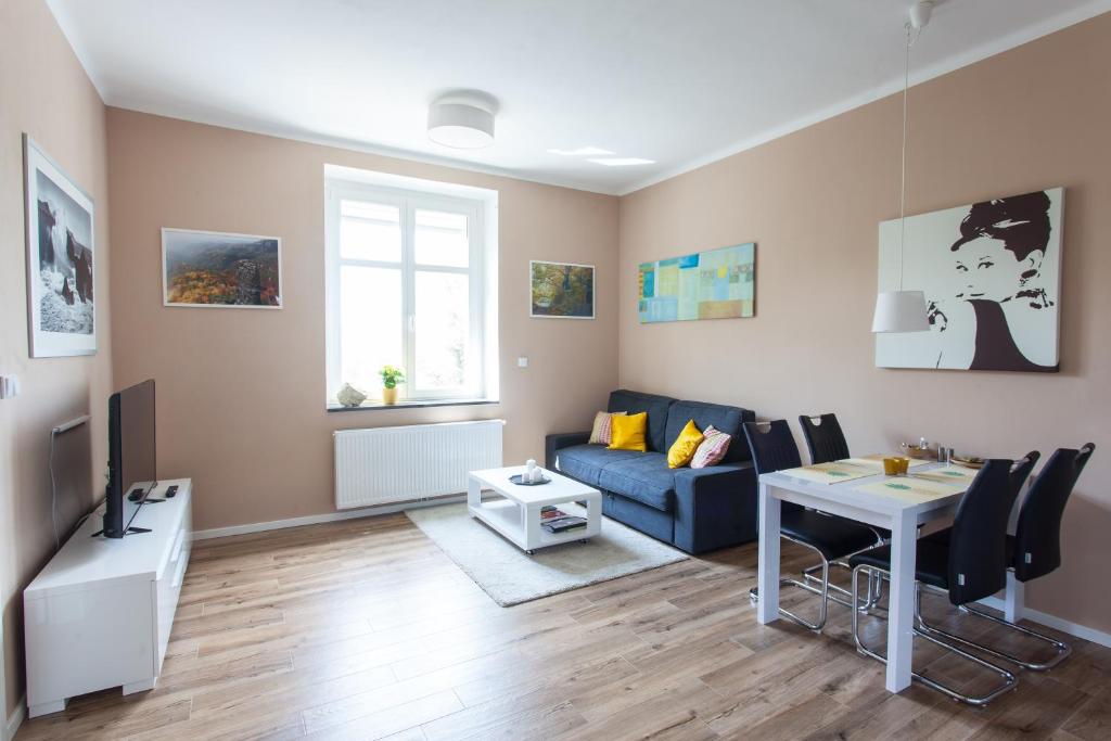 a living room with a blue couch and a table at Eliška in Prague