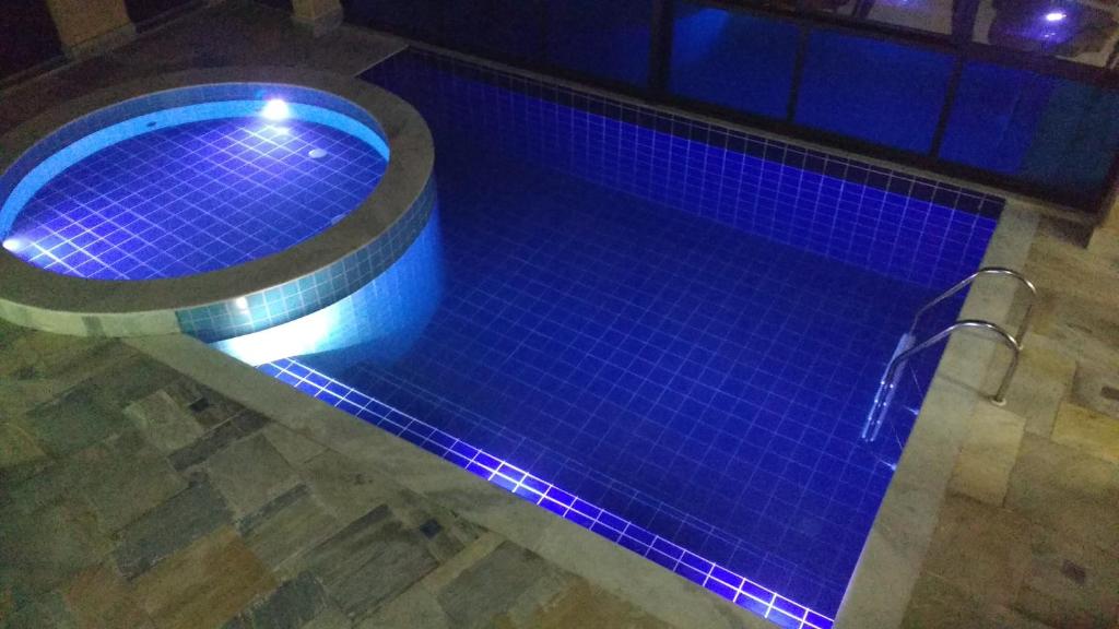 una piscina con luces azules en el suelo en Pousada Ubuntu, en Ubatuba