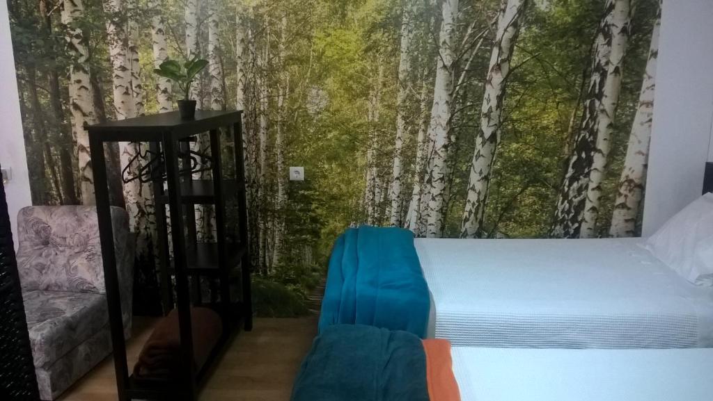 a bedroom with a bed and a tree mural at Casa do Limoeiro in Quinta do Conde