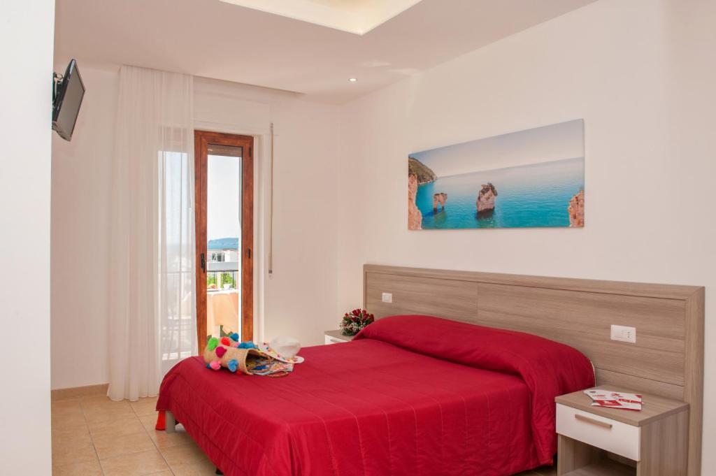 una camera con un letto rosso e una coperta rossa di Albergo San Giorgio a Vieste