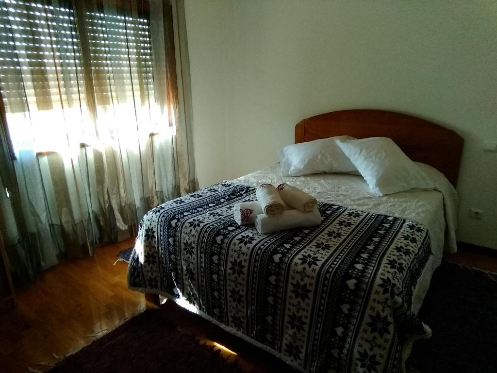 a bedroom with a bed with two teddy bears on it at Lélé in Vila Praia de Âncora