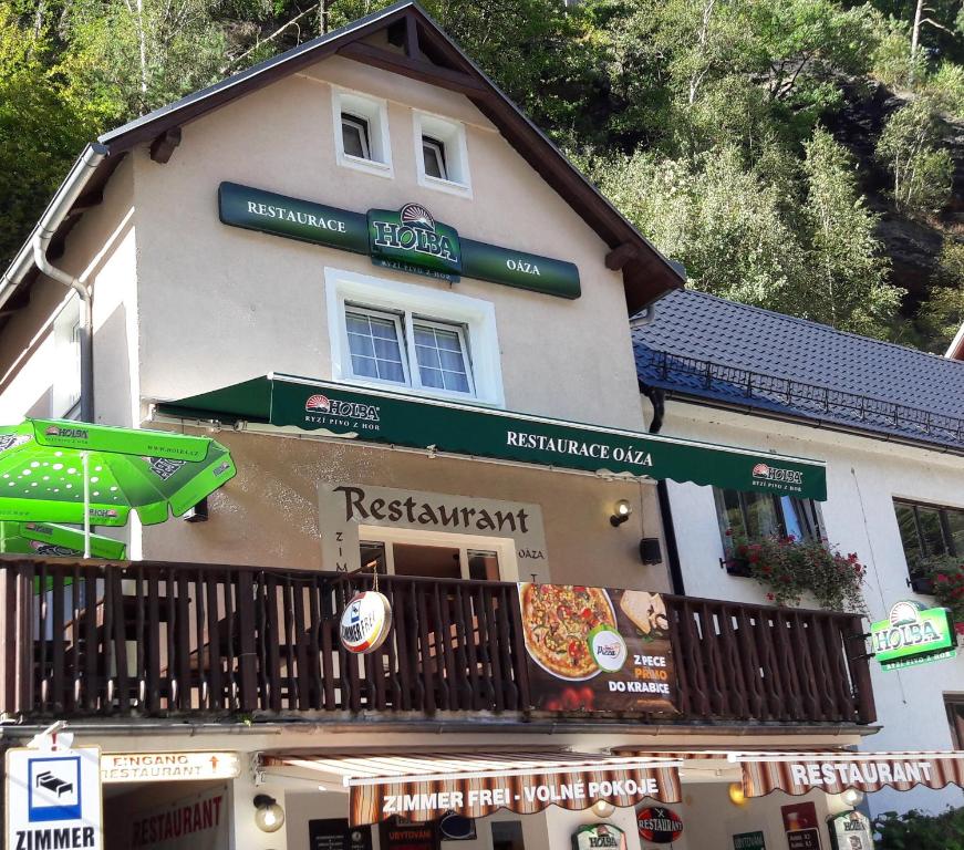 ein Gebäude mit Schildern auf der Vorderseite eines Restaurants in der Unterkunft Restaurace a Penzion Oáza in Hřensko