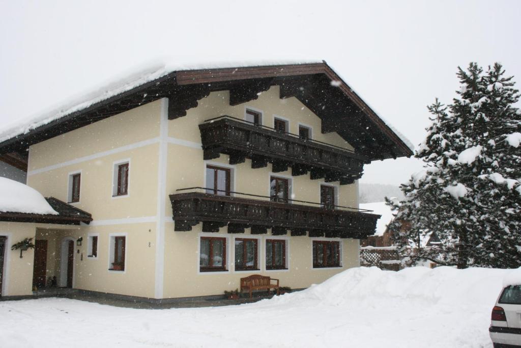フラッハウにあるHaus Weitgasserの大きな家 雪の中にバルコニー付