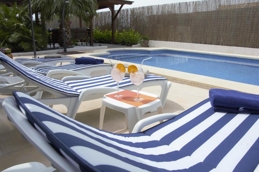 een groep blauwe en witte stoelen en een zwembad bij Hotel Vista al Sol in Paterna